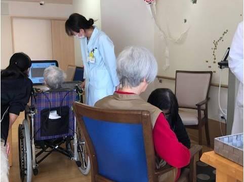 高齢者向け住宅で健康イベントを行う薬剤師と医療事務