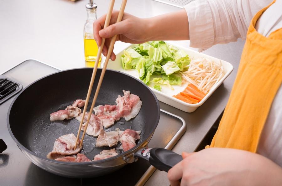 フライパンで肉を炒めている様子