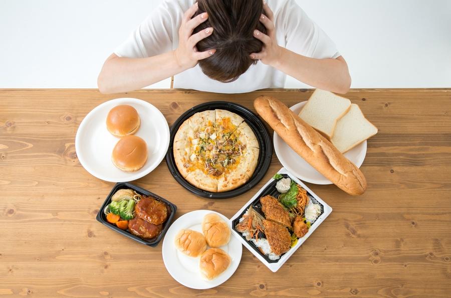 糖質の多い食事を目の前に頭を抱える女性