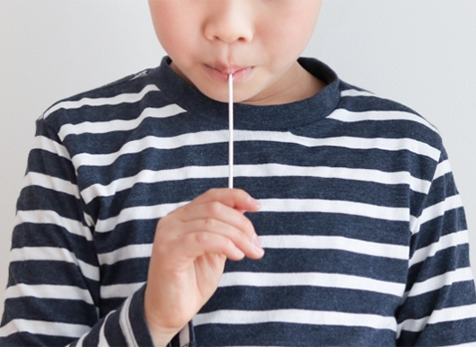 「スワブ法」で検体採取をする男の子