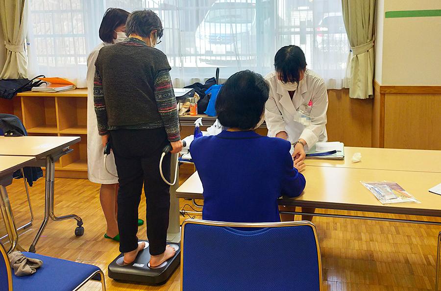 患者さまに体組成測定、パルスオキシメーター測定を実施する薬剤師、管理栄養士