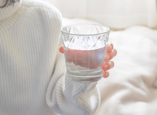 女性が手に持つコップ1杯の水