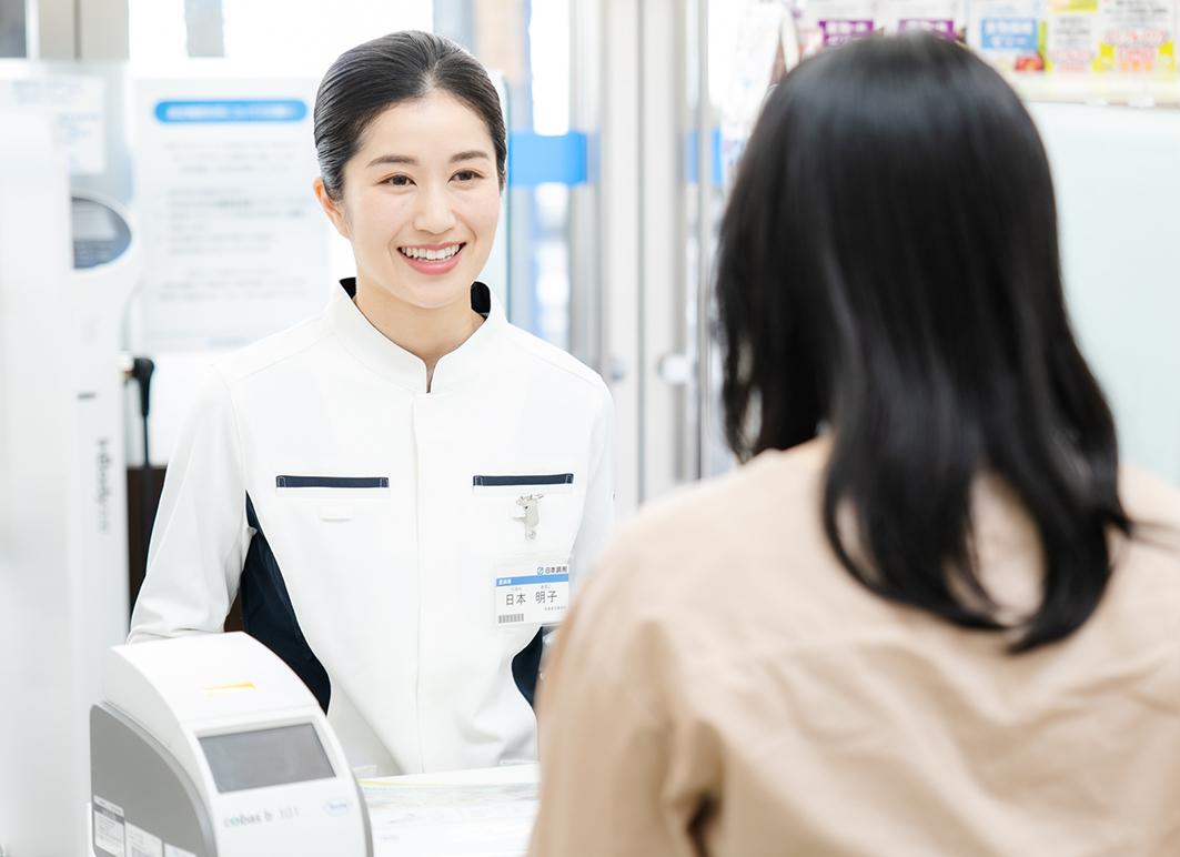 薬剤師が簡易血液測定について患者さまに説明する様子