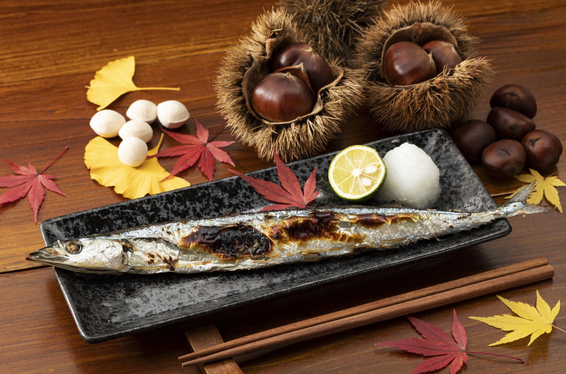 秋の食材の周りに散らばっている紅葉とイチョウ