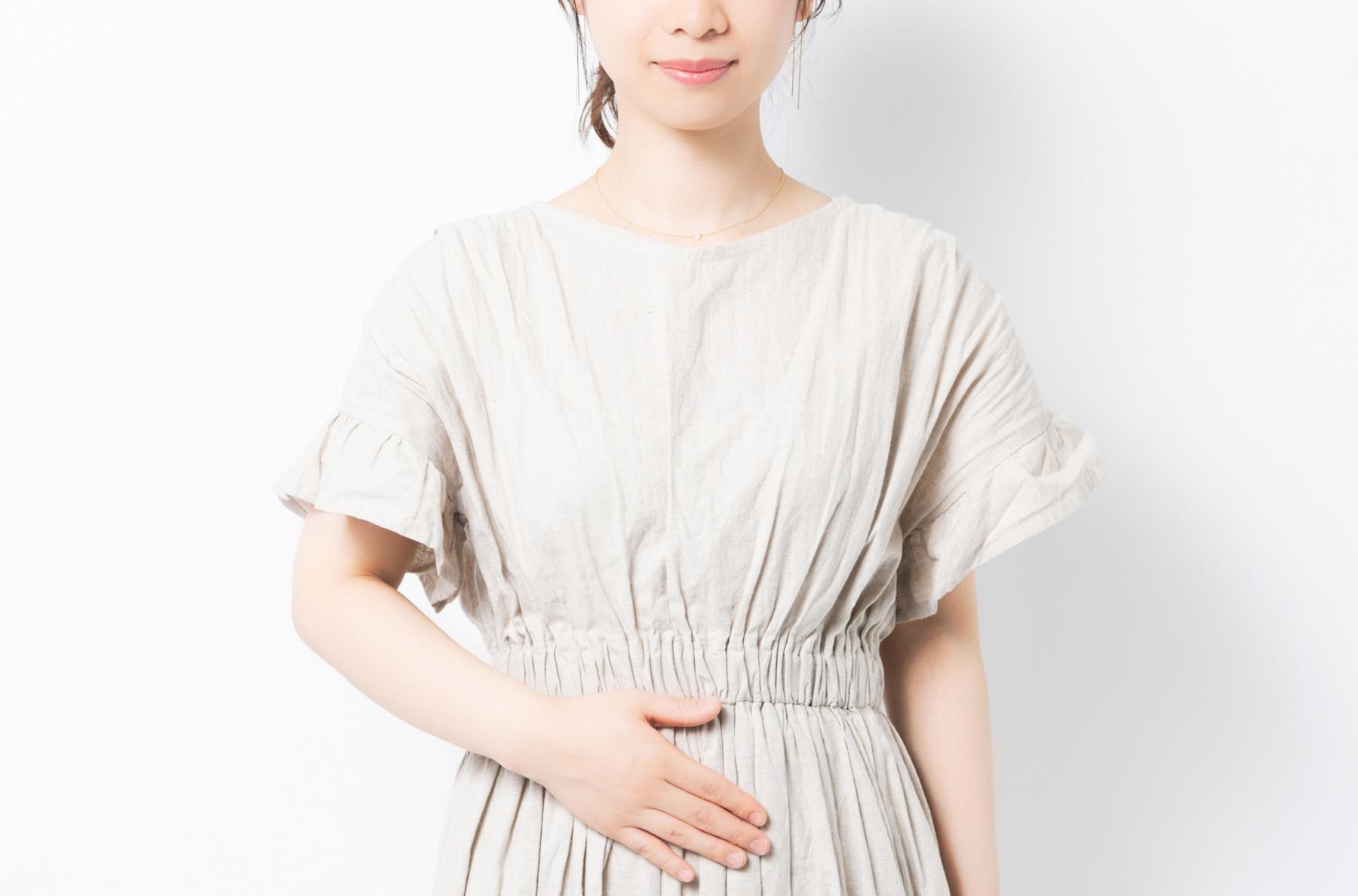 お腹に手を当てている女性