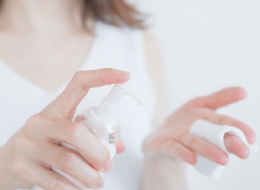 コットンに保湿液を出している女性