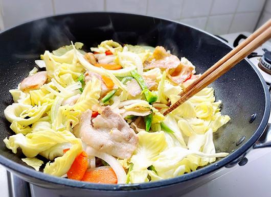 フライパンいっぱいの野菜炒めをつくっている様子
