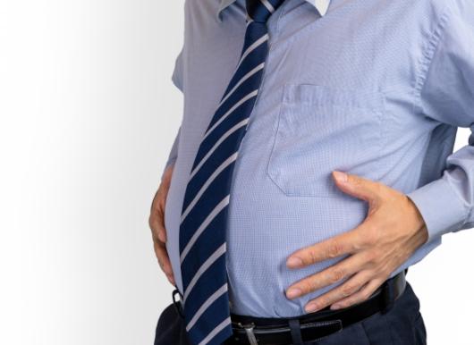 お腹の脂肪が気になるシャツ姿の男性