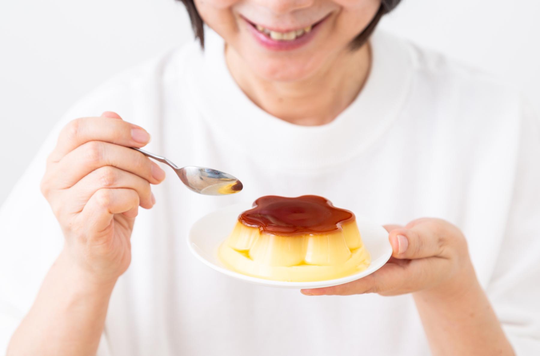 プリンを食べようとしている高齢女性