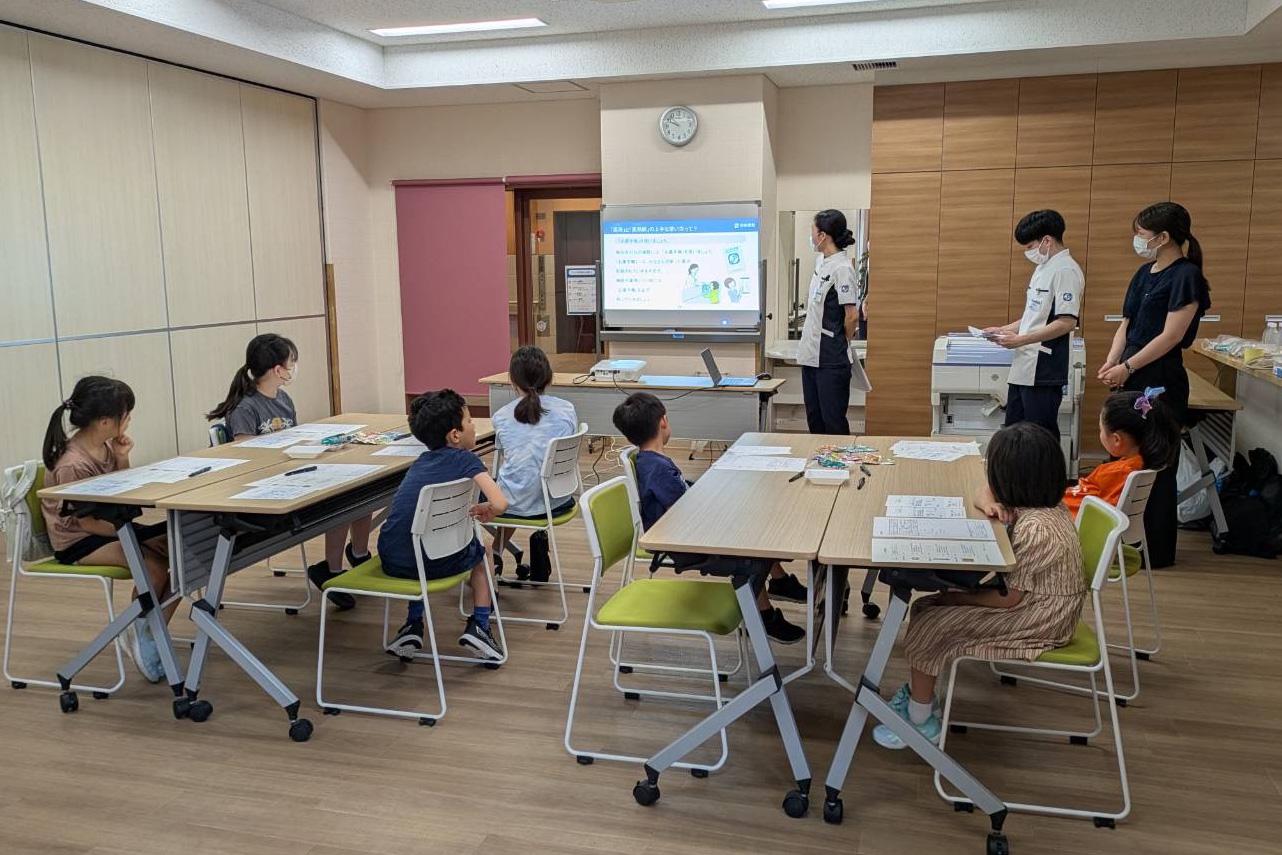 日本調剤の子ども薬剤師体験イベントで子どもたちに講義する様子
