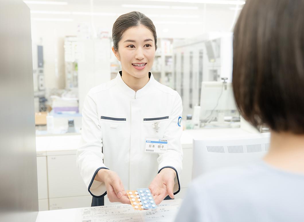 カウンターで服薬指導を行う薬剤師