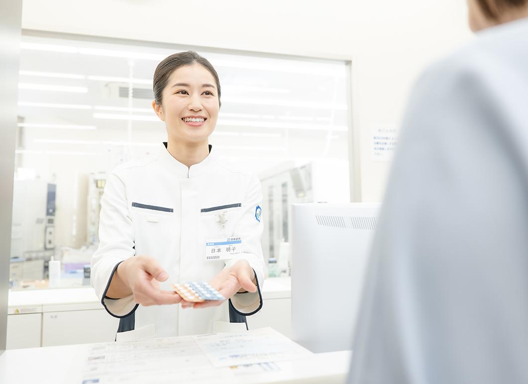 カウンターで服薬指導を行う女性薬剤師