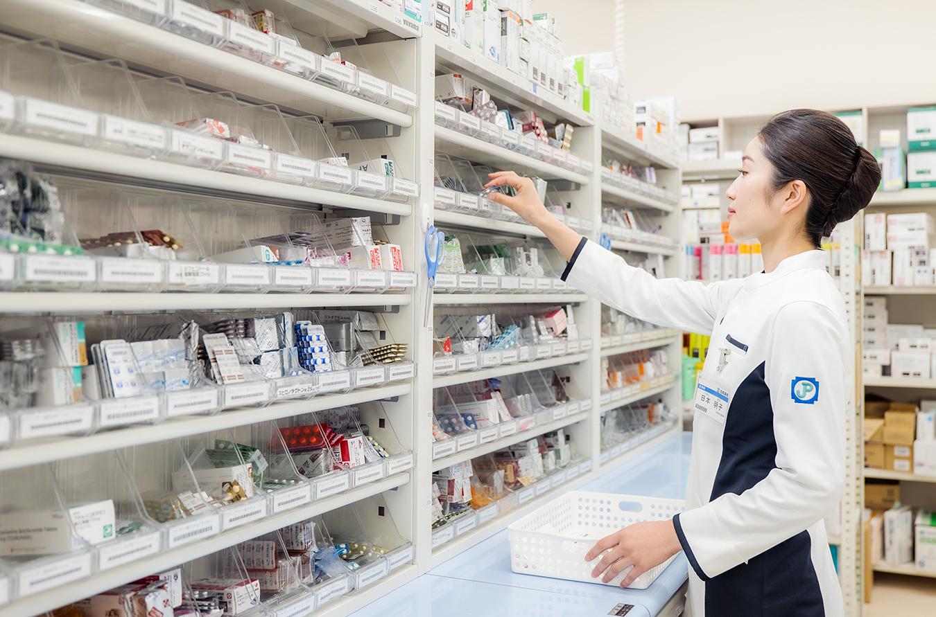 調剤棚からピッキングする薬剤師