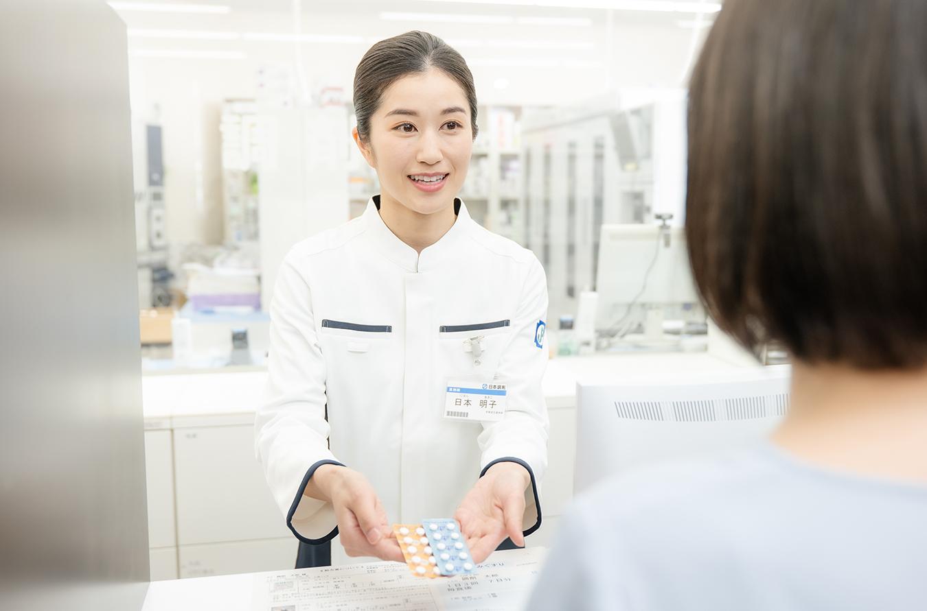カウンターで服薬指導を行う薬剤師
