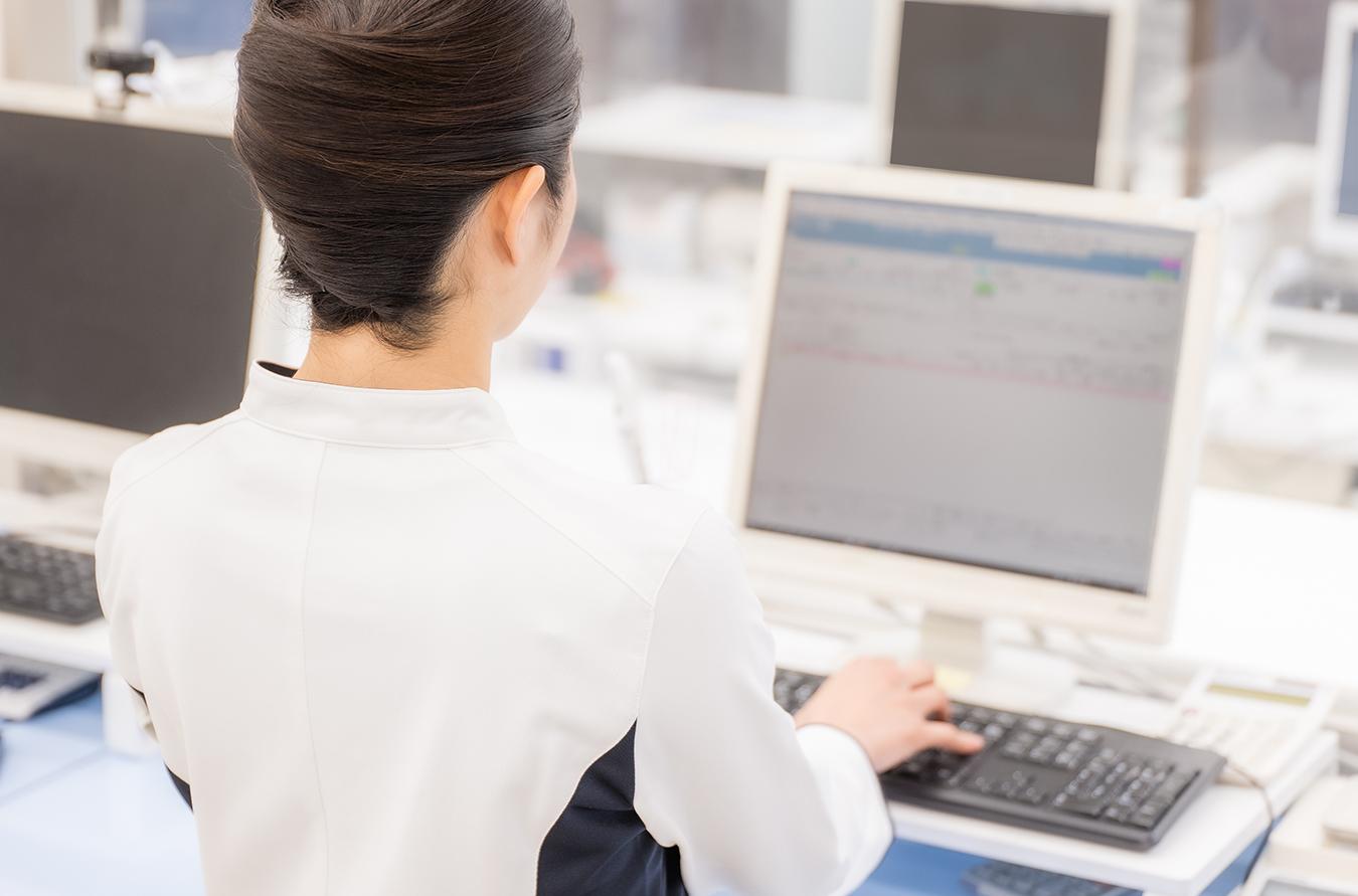 PCに向かい調剤システム入力をする薬剤師