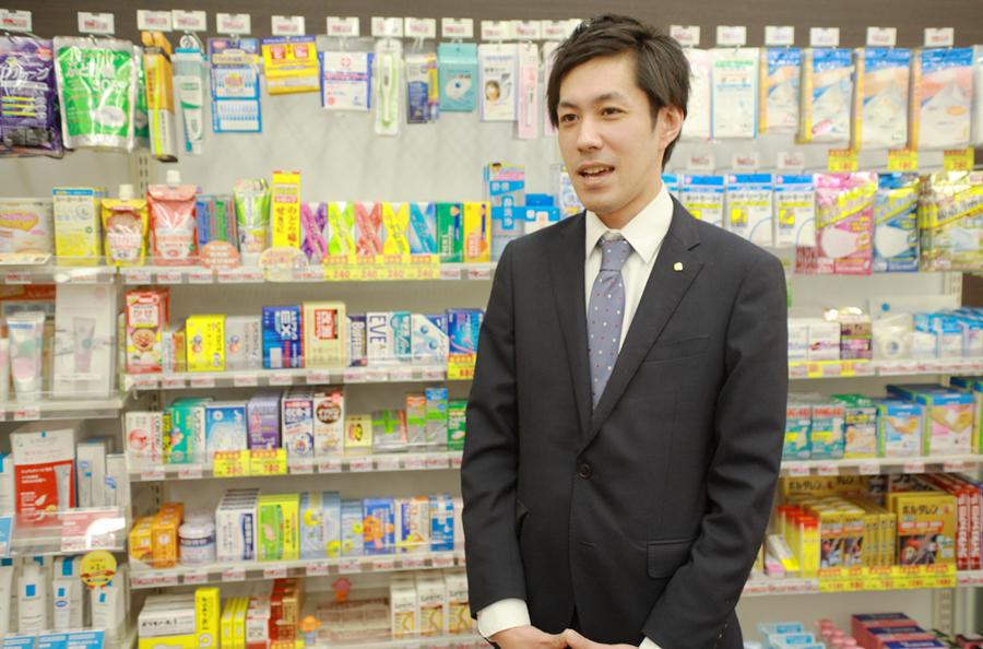 OTC医薬品が並べられた棚の前に立つ薬剤師